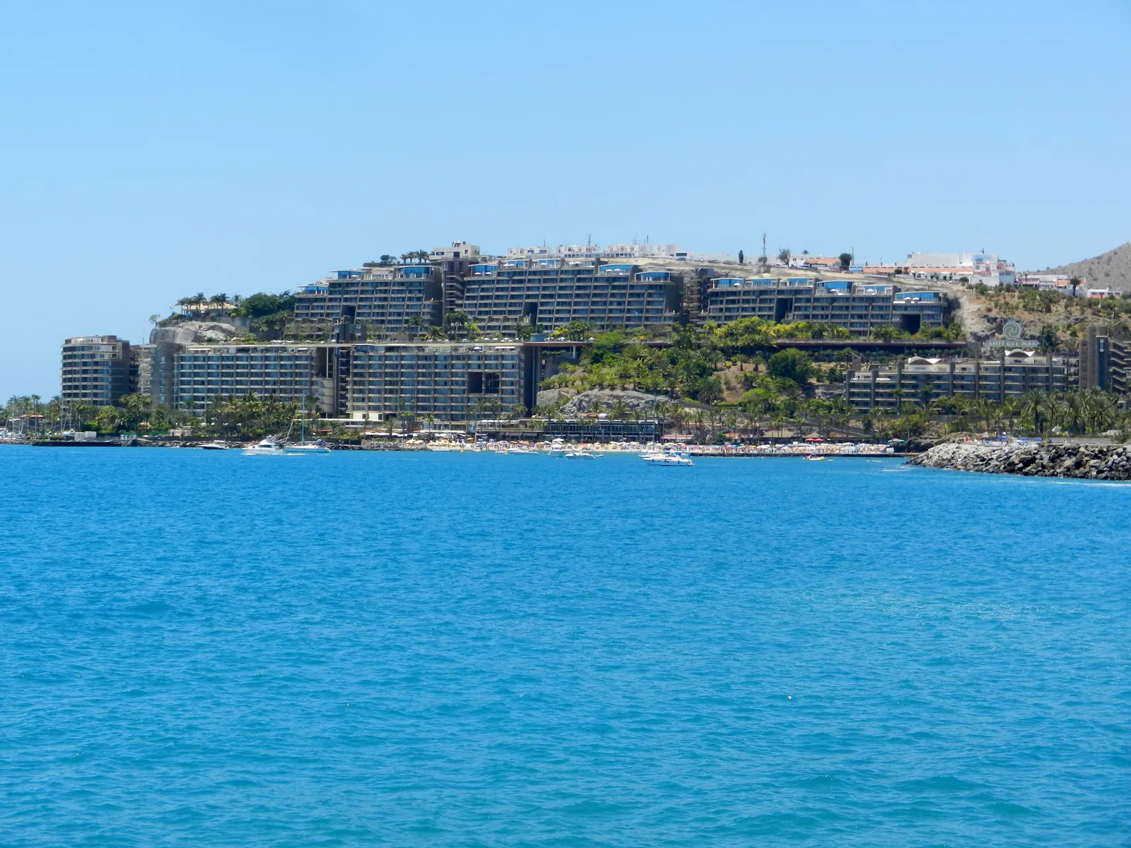 Clear blue water off the Anfi del Mar coast with the resort buildings on the hillside