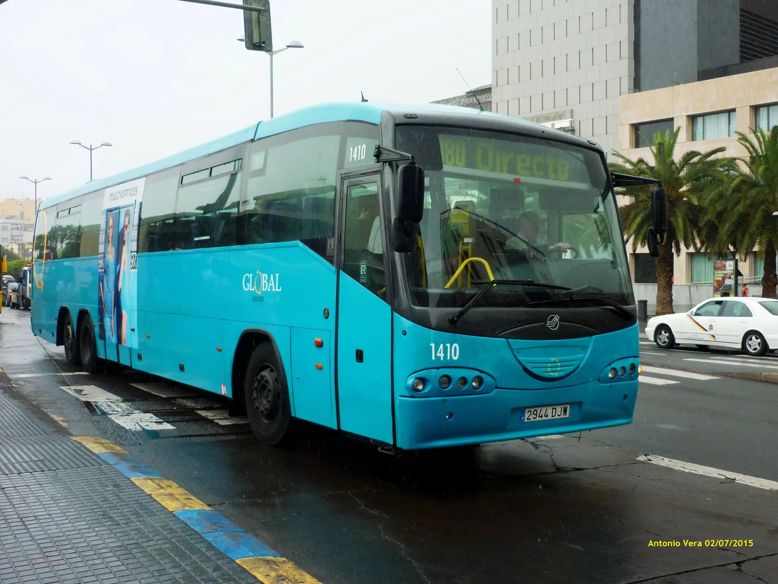 Turquoise Global intercity bus at a stop in Las Palmas on a rainy day