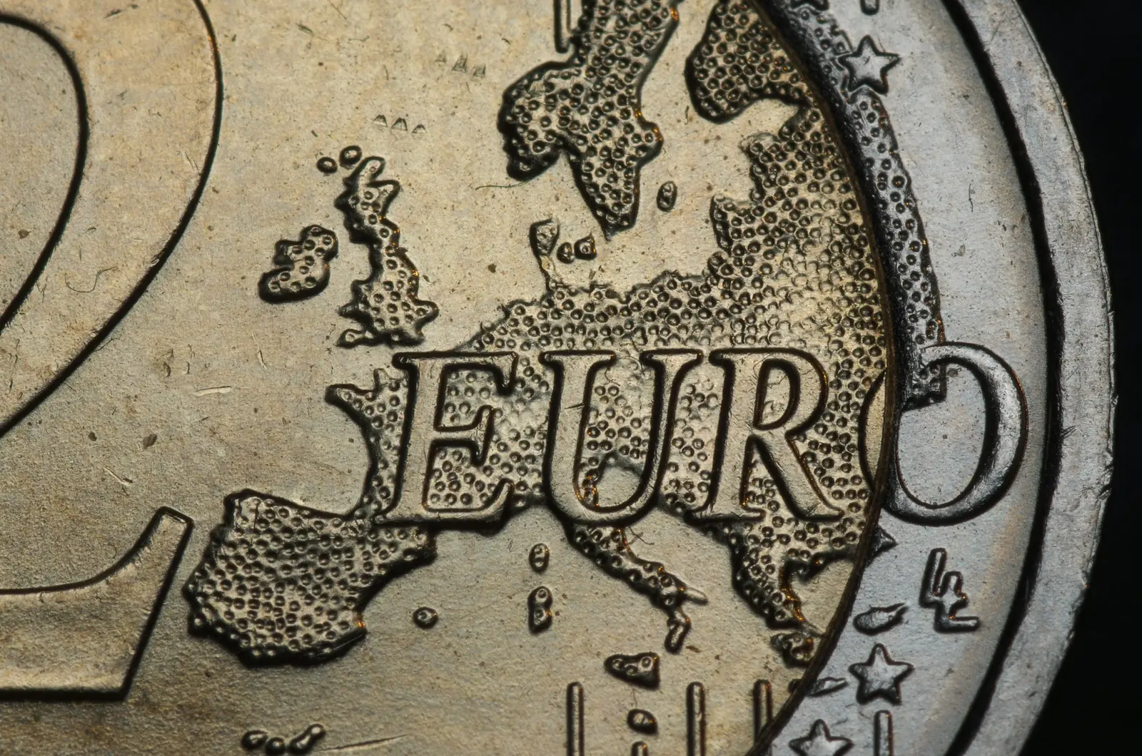 Close-up of a two-euro coin showing the word EURO over a relief map of Europe