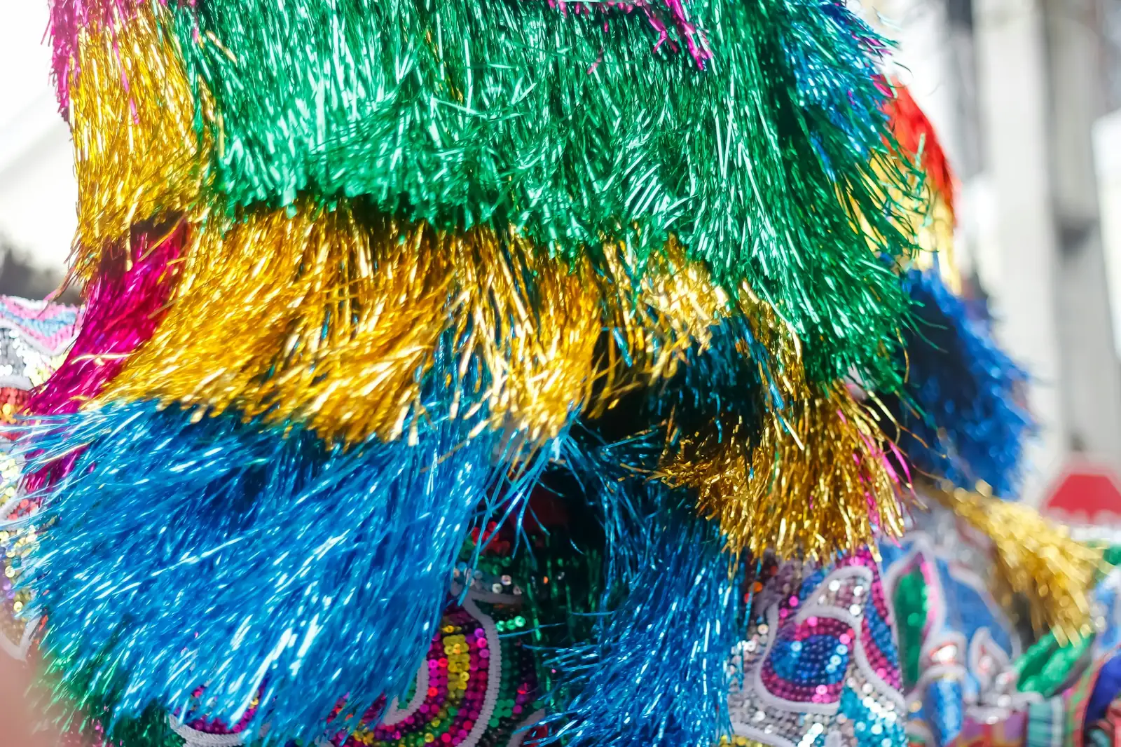Close-up of green, gold and blue tinsel fringe and sequins on a carnival costume