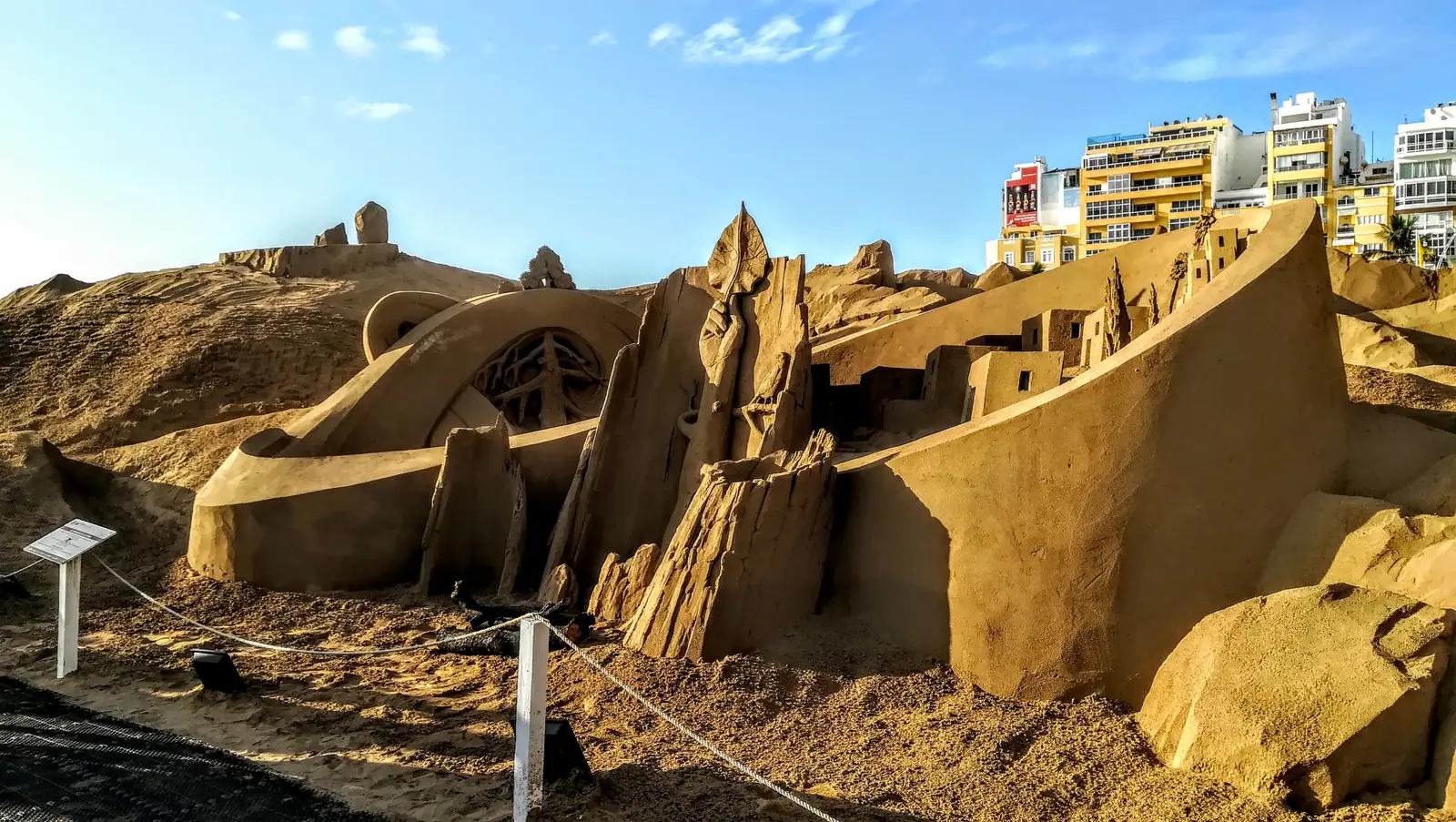 Sand nativity sculpture on Las Canteras beach in Las Palmas de Gran Canaria with apartment blocks behind