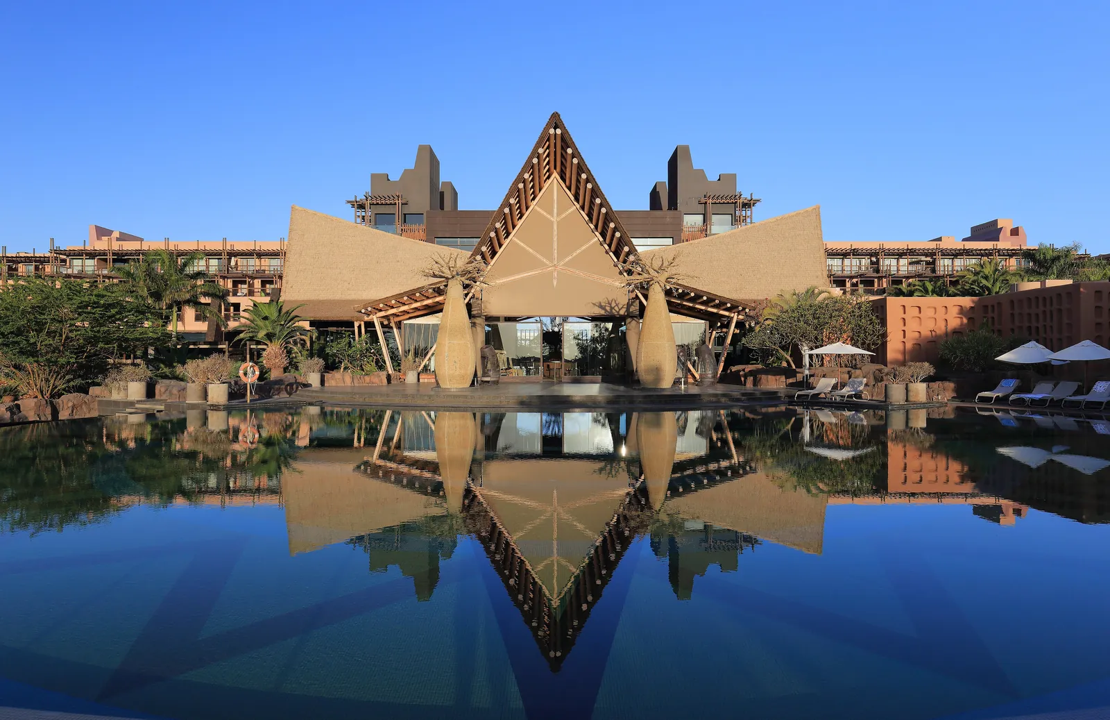 Resort hotel reflected in a still swimming pool at dusk in Maspalomas, Gran Canaria